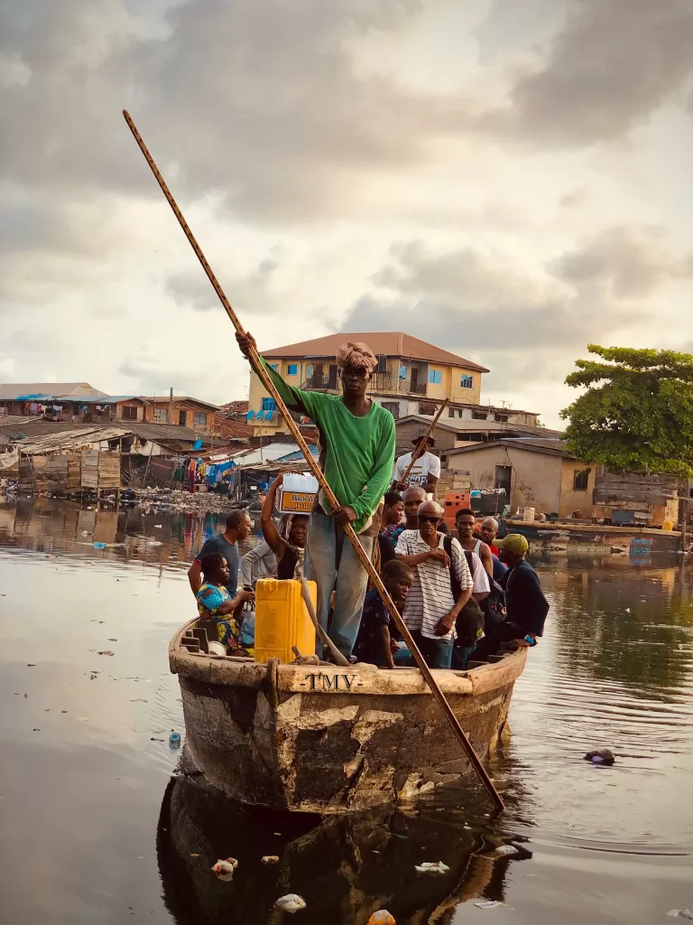 A group of students in Makoko are rowed by a boat on the way to school.